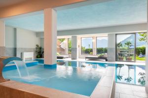 a large swimming pool with blue water in a house at Hotel Residence MaVie in Lagundo