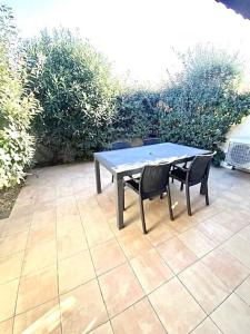 a table and two chairs sitting on a patio at T2 cabine avec piscine collective, parking, climatisation pour 4 personnes in Saintes-Maries-de-la-Mer