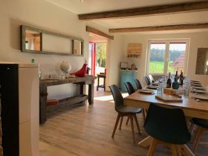 a dining room with a long wooden table and chairs at Le Pas Sans Peine in Le Cergne