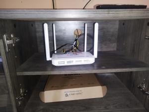 a router sitting on top of a box on a shelf at Nurul Homestay in Kepala Batas