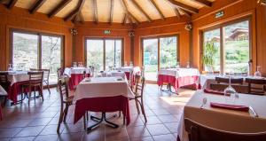 a dining room with tables with red and white table cloth at Paraiso Rural in Villanueva de Cameros +22 photos
