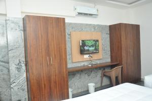 チクマガルールにあるBesuge comfortsの壁にテレビが付いた部屋