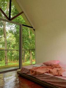 una camera da letto con un letto e una grande finestra di Balay Hilway - Cozy Rustic Cabin a Sara