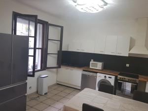 una cocina con lavadora y microondas en Apprt'Nadia, en Aviñón