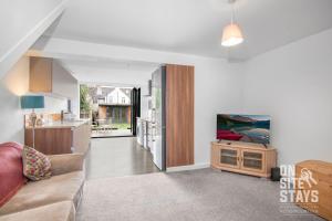a living room with a couch and a kitchen at OnSiteStays Dartford 4BR House with Garden, bathroom and ensuite in Dartford