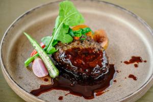 a plate of food with meat and vegetables on it at Glamday Style Okinawa Yomitan Hotel & Resort in Yomitan