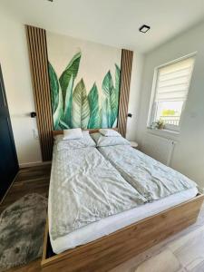 a bedroom with a bed with a mural on the wall at Apartamenty Dębowa 27 in Milicz