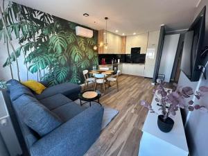 a living room with a blue couch and a kitchen at Apartamenty Dębowa 27 in Milicz