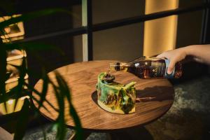 a person pouring a bottle of beer on a table at Glamday Style Okinawa Yomitan Hotel & Resort in Yomitan