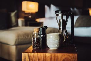 a table with a bottle and a cup on a table at Glamday Style Okinawa Yomitan Hotel & Resort in Yomitan