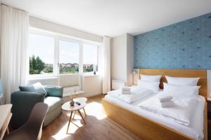 a bedroom with a large bed and a couch at Bades Huk Marina Hotel in Hohen Wieschendorf +14 photos