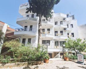 a white building with a tree in front of it at Golden Beach Hotel in Didim