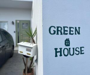 浦添市にあるＧＲＥＥＮ　ＨＯＵＳＥの建物脇の緑の家看板