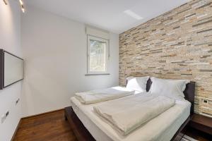 una cama en una habitación con una pared de ladrillo en Ad Maiora with Shared Pool, en Rabac 15 fotos más