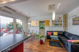 Una sala de estar con un sofá negro y una mesa. en Ad Maiora with Shared Pool, en Rabac