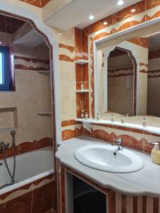 a bathroom with a sink and a bath tub at Maria's family house 1 in Elafonisos