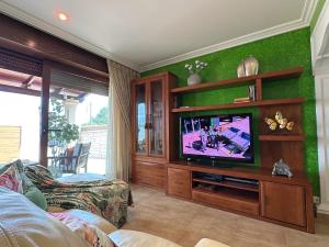 sala de estar con TV de pantalla plana en una habitación en Villa as pipas, en O Grove