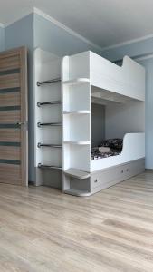 Litera blanca en habitación con suelo de madera en Magnetiti, en Ureki