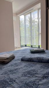 Un dormitorio con dos camas y una gran ventana. en Magnetiti, en Ureki