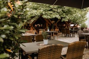 a restaurant with tables and chairs and trees at Landhotel Gary in Wolframs-Eschenbach