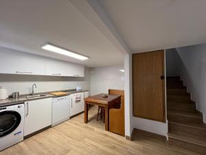 eine Küche mit Spüle, Tisch und Treppe in der Unterkunft MartinVidal 1 in Luarca