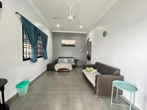 a living room with a couch and a bed at Aqua Shelter in Mersing