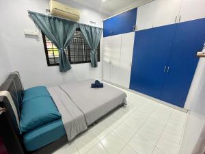 a bedroom with a bed with blue cabinets and a window at Aqua Shelter in Mersing
