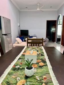 a living room with a table with a plant on it at Aqua Shelter in Mersing