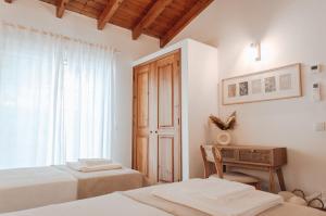 Un dormitorio con dos camas y un escritorio y una ventana. en Slow House Green Villa, en São Brás de Alportel