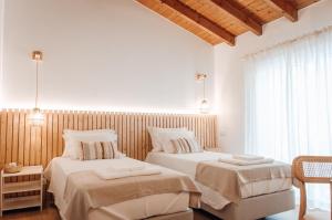 Dos camas en una habitación con paredes blancas. en Slow House Green Villa, en São Brás de Alportel