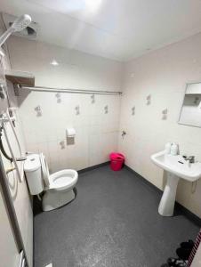 a bathroom with a toilet and a sink at Aqua Shelter in Mersing