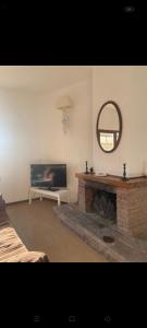 un soggiorno con camino e specchio di Casa CAREN a Santa Maria di Castellabate