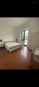 una grande camera con due letti e una finestra di Casa CAREN a Santa Maria di Castellabate