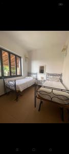 una camera da letto con due letti e una finestra di Casa CAREN a Santa Maria di Castellabate