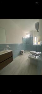 un bagno con lavandino, WC e specchio di Casa CAREN a Santa Maria di Castellabate