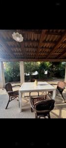 un tavolo bianco e sedie sotto un tetto di Casa CAREN a Santa Maria di Castellabate