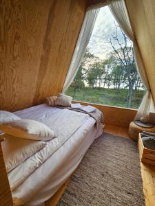 a bed in a room with a large window at Lidö Värdshus in Lidö