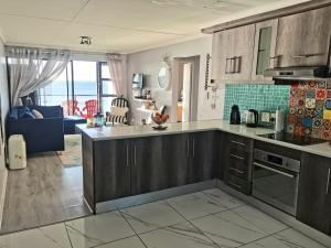 イースト・ロンドンにあるClassy Beach Apartmentの海の景色を望むキッチン(木製キャビネット付)