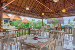 Un restaurante con mesas y sillas en un balcón. en D'Arya Sea View, en Nusa Penida