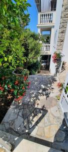 a stone walkway in front of a building with flowers at Apartments Marijana in Zavalatica