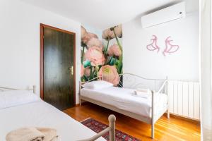 een slaapkamer met 2 bedden en een muurschildering van bloemen aan de muur bij Beautiful luxury house w sea view & outside space in Split