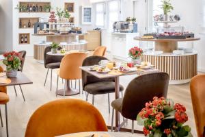 a restaurant with tables and chairs with food on them at Hotel Italia in Cagliari