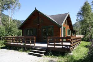 a small wooden house with a porch and stairs to it at Buøy Camping in Dalen