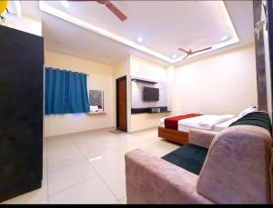 a bedroom with a bed and a couch and a tv at Hotel VSR Grand in Vijayawāda +13 photos