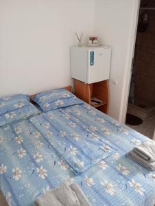 a bedroom with a bed with a blue comforter at Casa Eliza in Corbu +4 photos