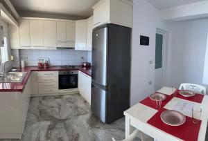 a kitchen with a refrigerator and a table in it at Nostos Palase in Dhërmi