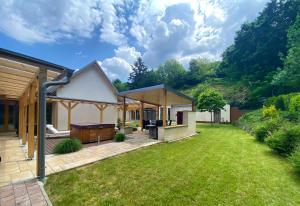 a garden with a house and a lawn at Villa Quality Wellness in Dozmat