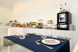 a table with a plate and fork and a microwave at Blumarin in Lido di Jesolo +20 photos