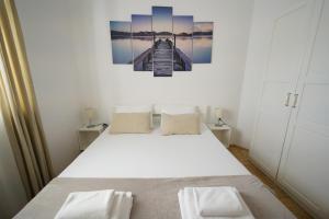 a bedroom with a bed with a painting on the wall at Apartments Loncar-near Zrće beach in Novalja