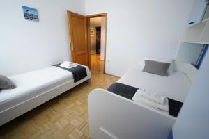 a room with two beds and a hallway at Apartments Loncar-near Zrće beach in Novalja